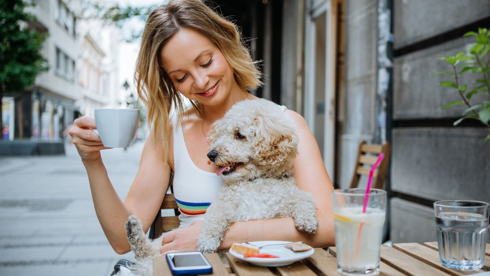 Mulher em café com cachorro.