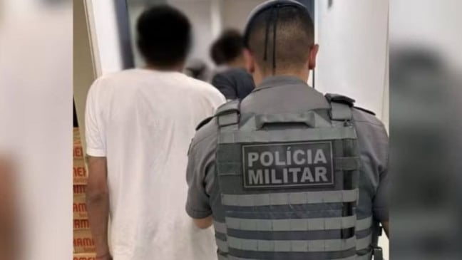 Agente da Polícia Militar levando suspeito de roubo de carga para delegacia