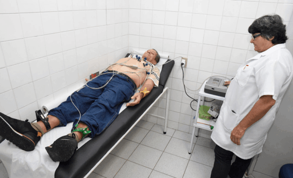 Paciente deitado em maca passando por eletrocardiograma