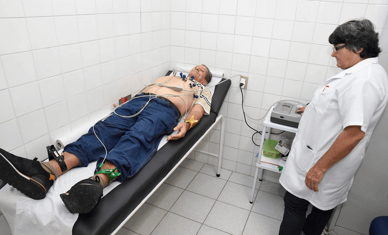 Paciente deitado em maca passando por eletrocardiograma