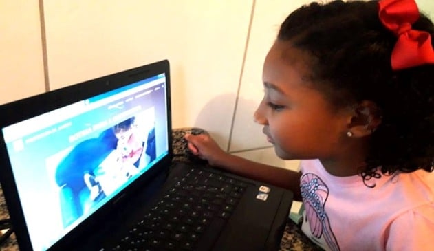 Foto de criança na frente de notebook