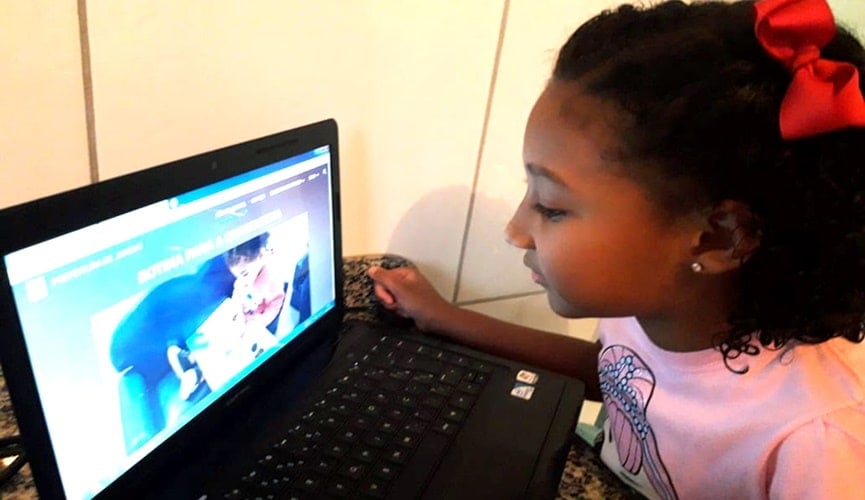 Foto de criança na frente de notebook