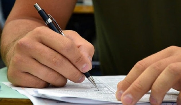 Mão escrevendo em folha de papel