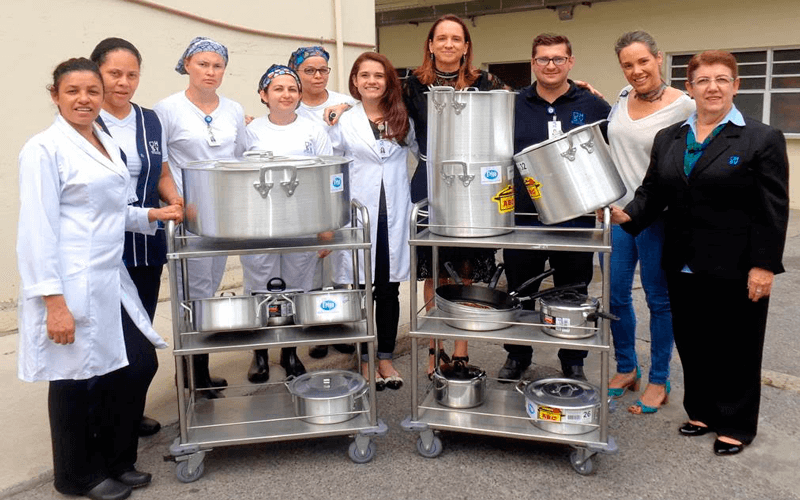 Equipe do HSV recebe a doação de panelas entregue por Ana Bretas, representante da Associação Nany Apple. (Foto: Divulgação)