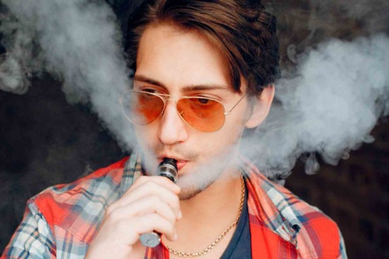 Homem jovem fumando cigarro eletrônico