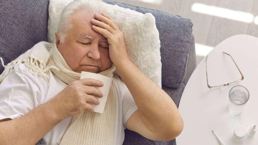 Idoso com gripe deitado em sofá Idoso com gripe deitado em sofá