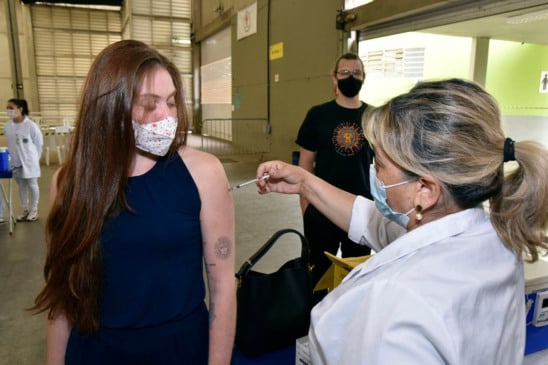 Jovem recebendo vacina no braço