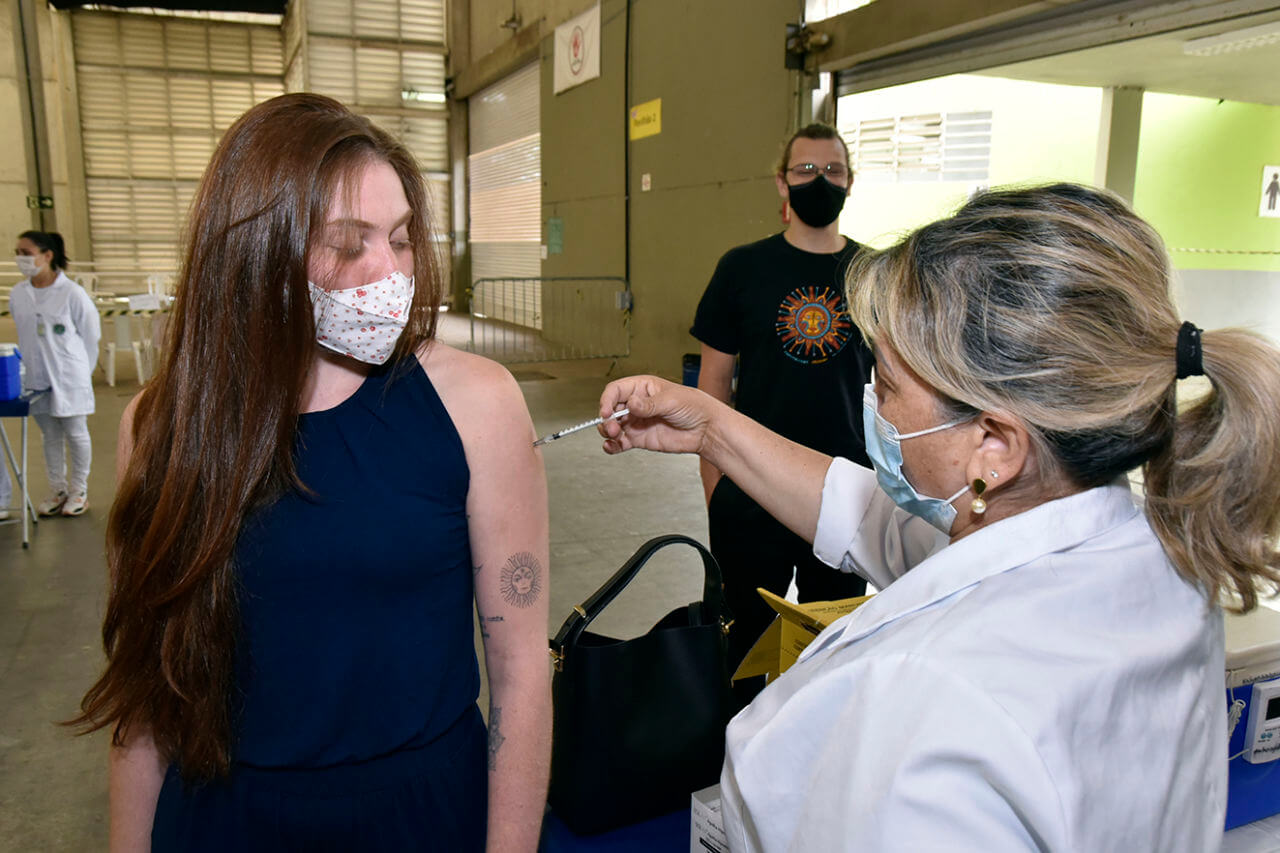 Jovem recebendo vacina no braço