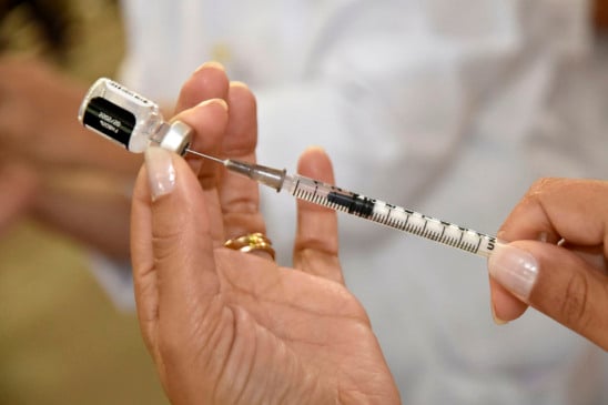 Pessoa administrando seringa de vacina