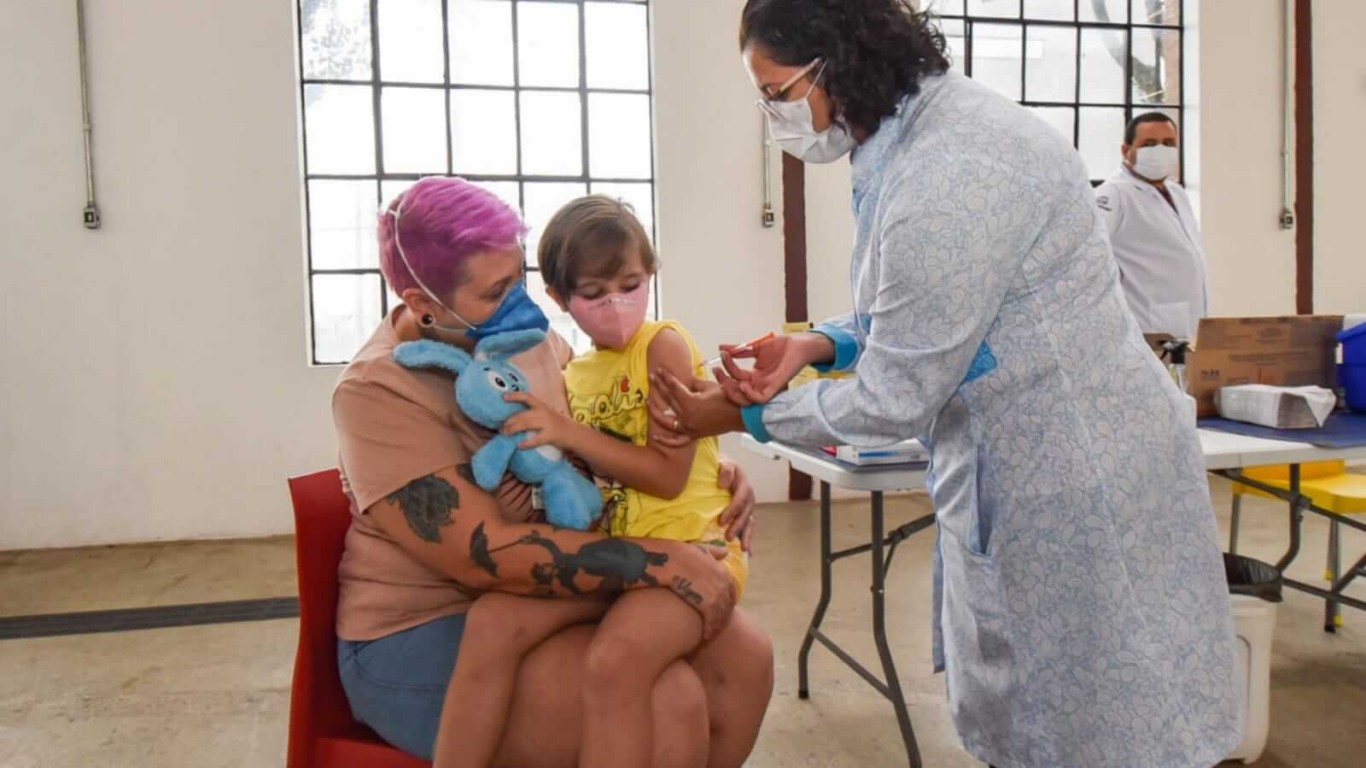 Menina sendo vacinada com ursinho de pelúcia