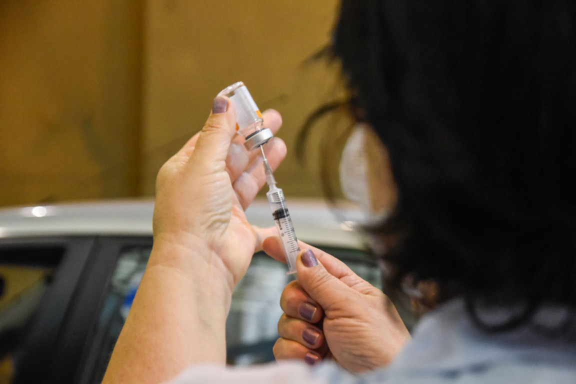 Mulher manuseando dose de vacina contra Covid19