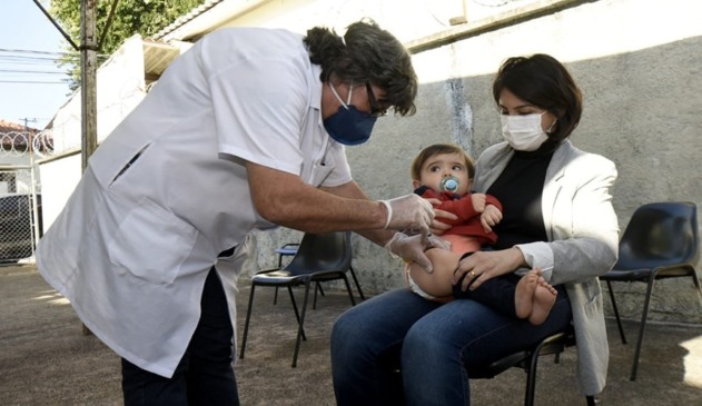 Foto de criança recebendo dose de vacina