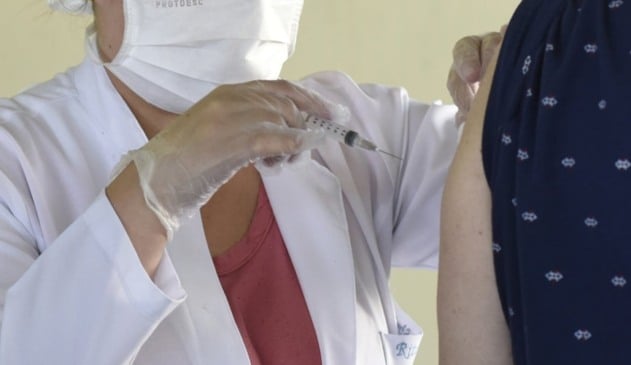 Enfermeira aplicando dose de vacina