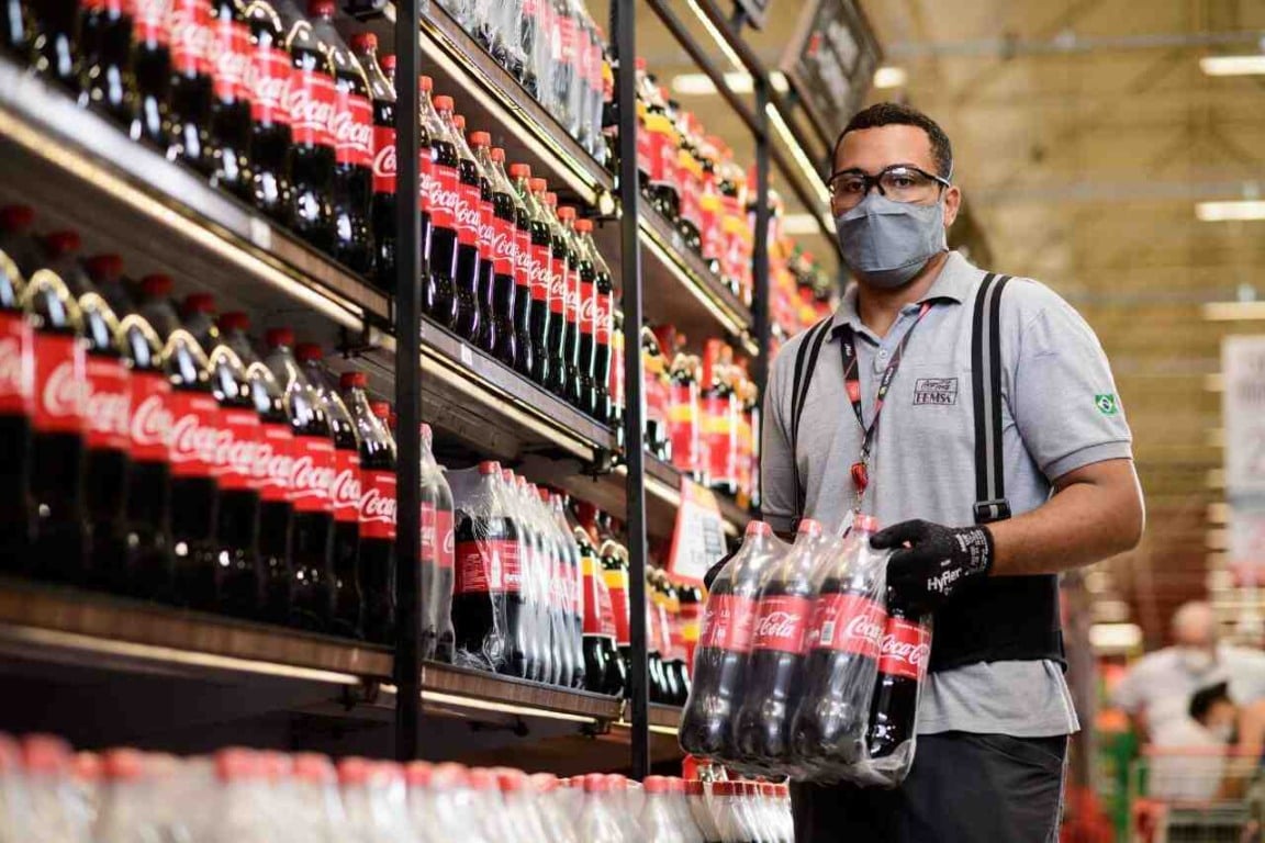 Homem segurando fardo de coca cola
