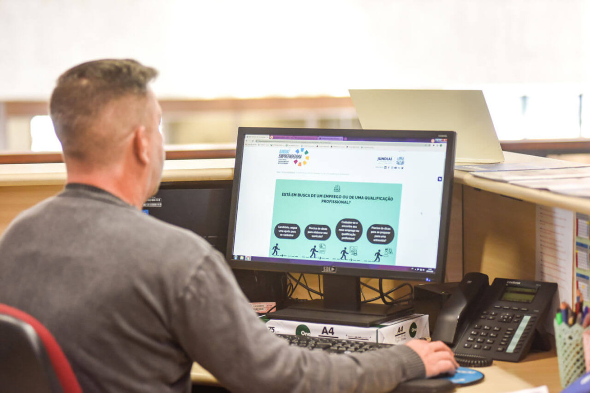 Homem com o portal Jundiaí empreendedora aberto no computador