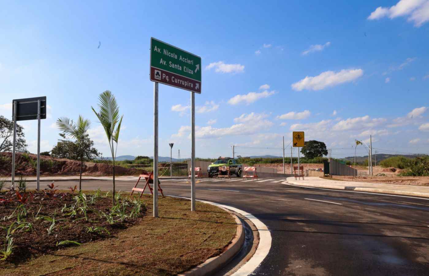 Novo viaduto no Currupira com placas indicativas para Av. Nícola Accieri e Pq. Corrupira, paisagismo e pista recém-asfaltada.