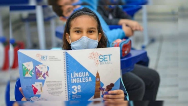 Aluna da rede estadual de Jundiaí segurando a apostila de inglês