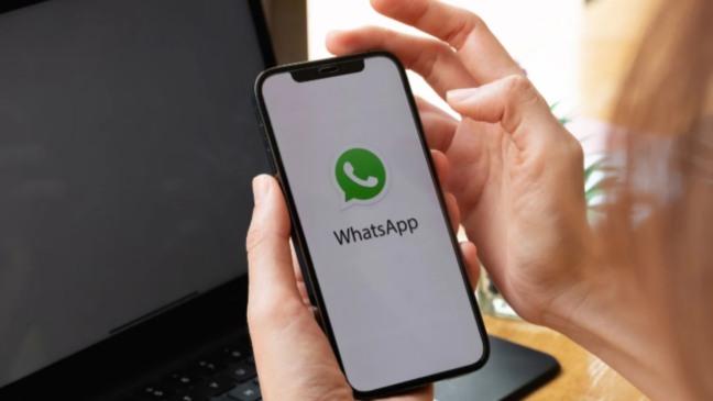 Mãos femininas mexendo em WhatsApp.