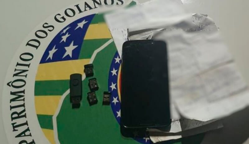 Celular e pen drives em cima de mesa