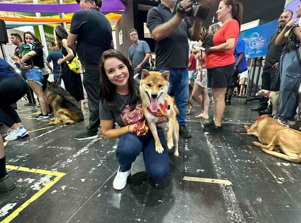 Tutora posando com seu cachorro no colo no desfile pet na 5ª FENS Jundiaí Tutora posando com seu cachorro no colo no desfile pet na 5ª FENS Jundiaí