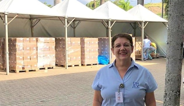 Foto de Selma Moraes ao lado da mercadoria de álcool em gel