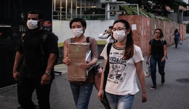 Foto de pessoas circulando de máscaras nas ruas