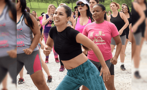 Mulher dança ao lado de grupo