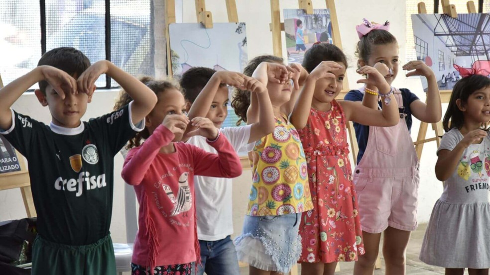 Crianças fazendo coração com as mãos