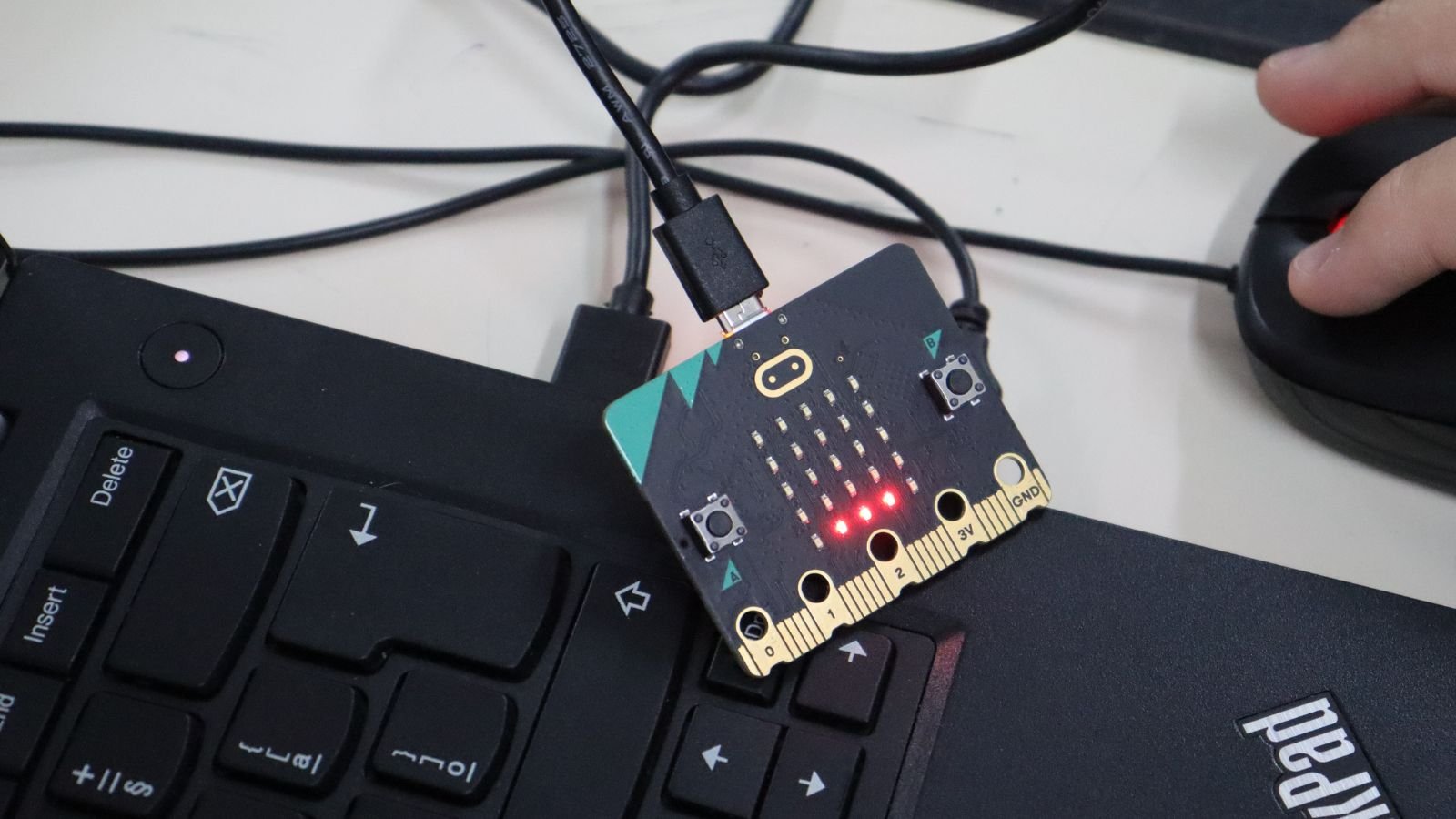 Uma pequena placa de circuito com um fio conectado a ela
