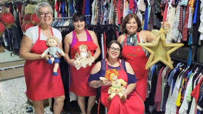 Voluntárias do bazar do Hospital São Vicente em frente às araras do espaço.