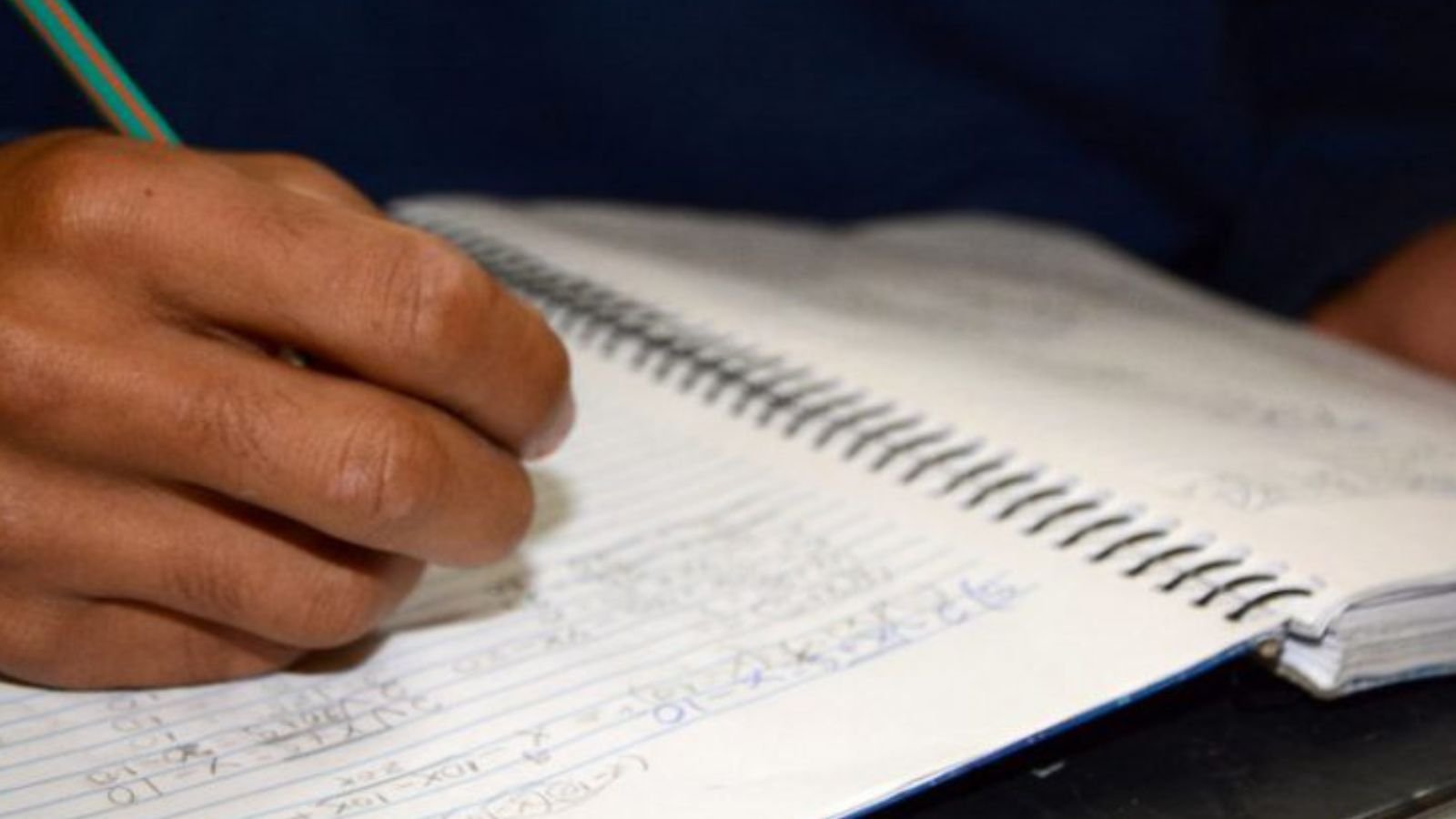 Mão de aluno da Fundação da CASA fazendo prova.