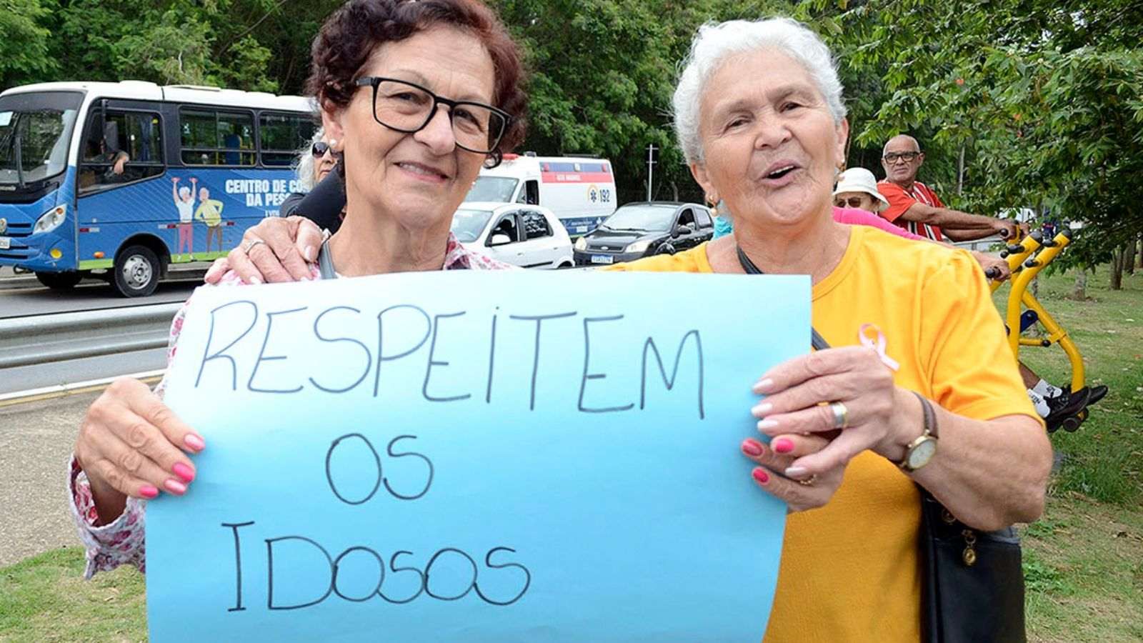 Idosos com cartaz pedindo respeito