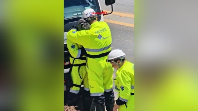 Socorristas se abraçam emocionados em frente a caminhão após morte de criança em acidente entre caminhões. Socorristas se abraçam emocionados em frente a caminhão após morte de criança em acidente entre caminhões.