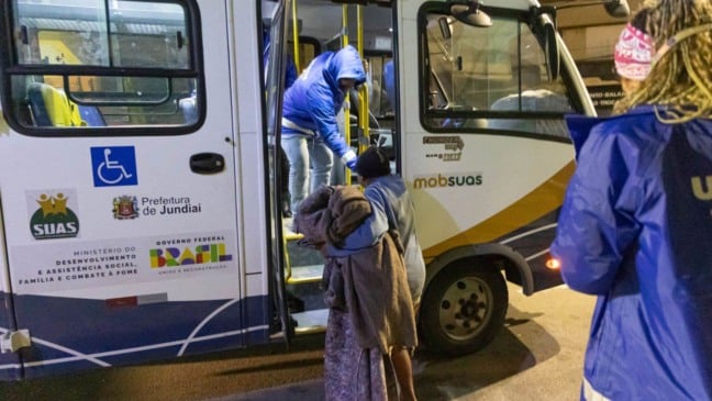 Morador de rua pegando ônibus