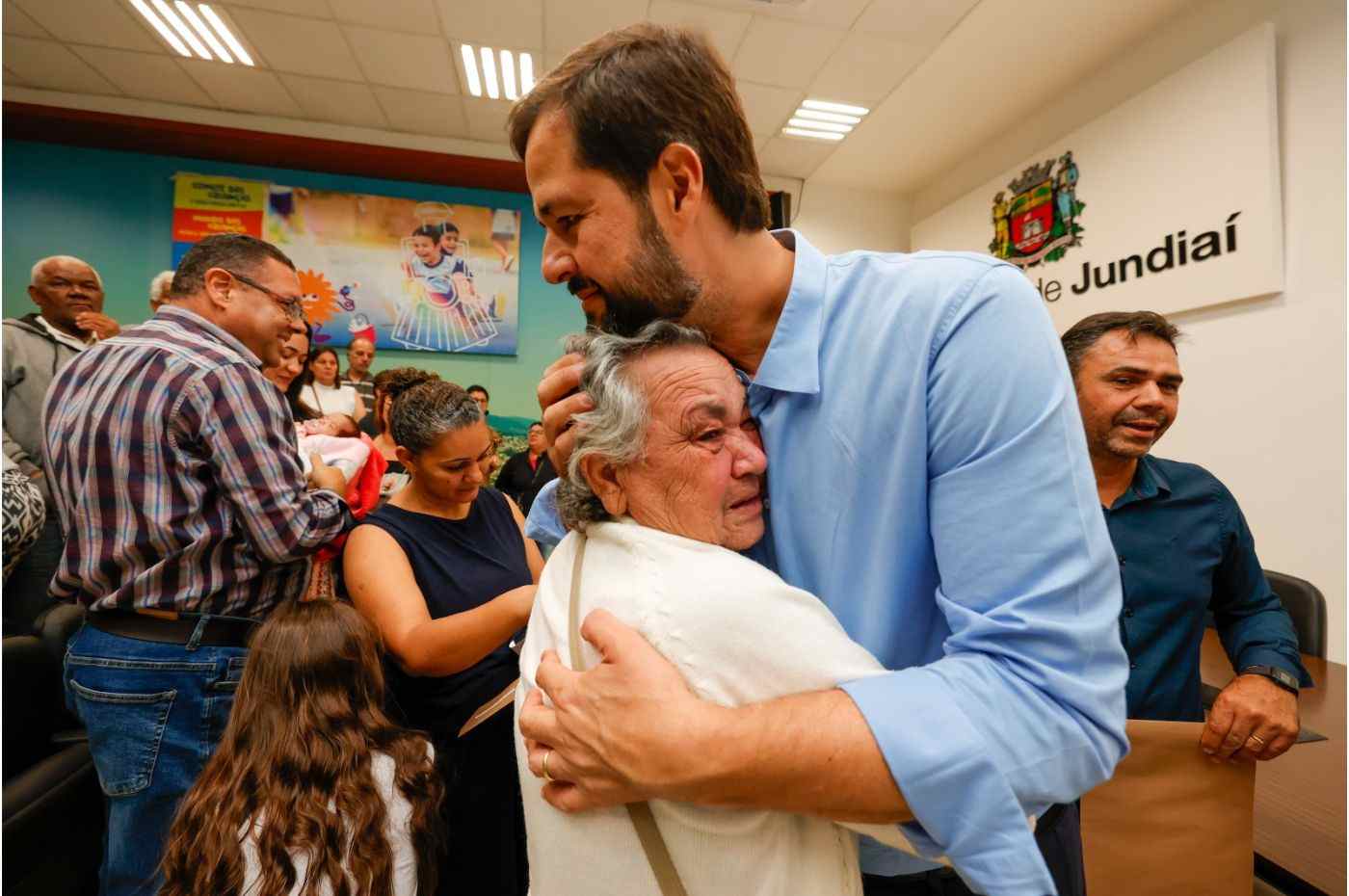 Prefeito Luiz Fernando Machado abraça moradora emocionada durante evento de regularização fundiária no Jardim Fepasa, em Jundiaí.