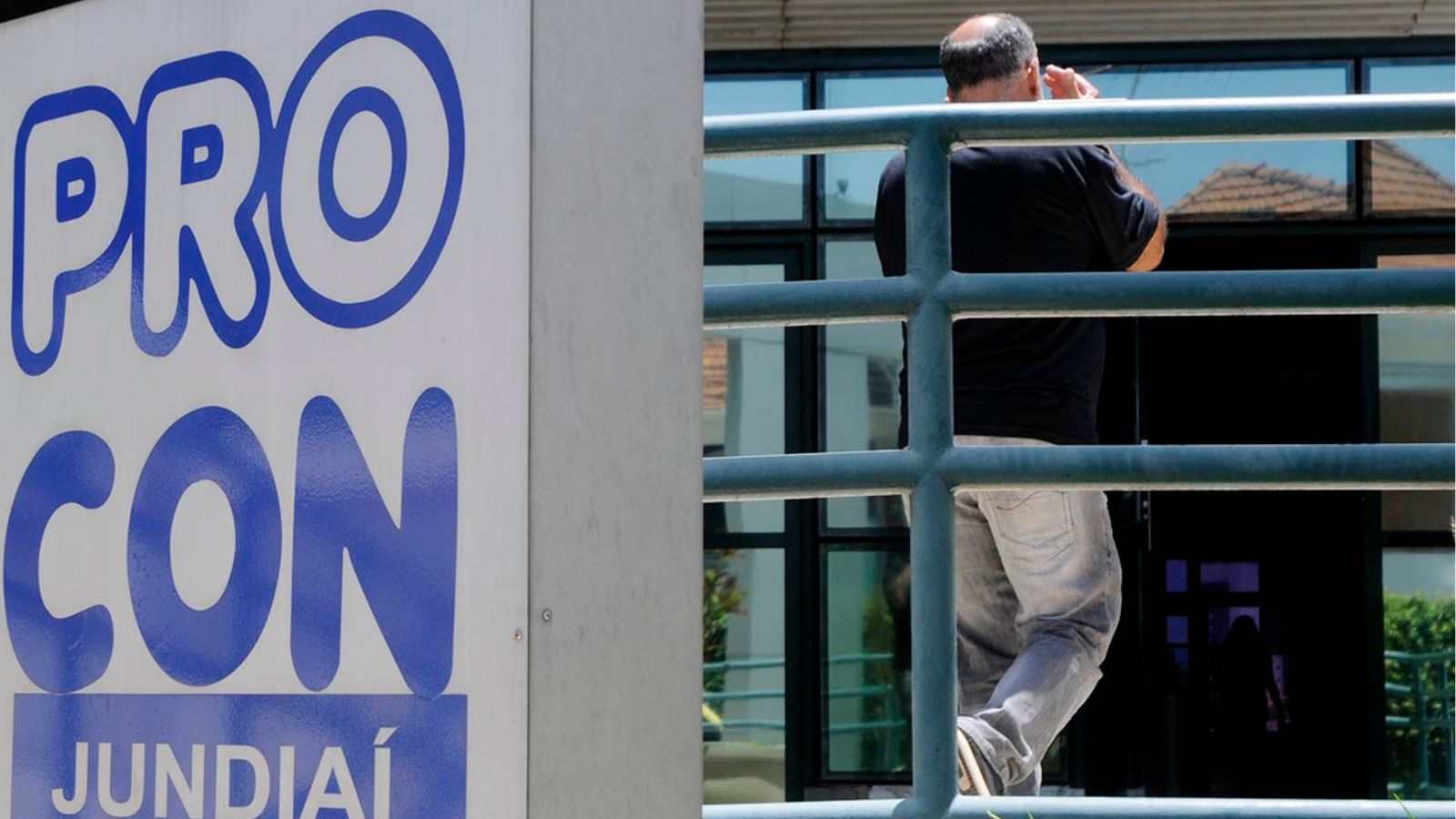 Placa do PROCON Jundiaí na fachada da unidade no Centro, com homem entrando no prédio para atendimento.