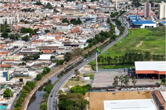 Vista aérea da Avenida Antonio Frederico Ozanan em Jundiaí, mostrando o rio Jundiaí, prédios e área comercial ao fundo.