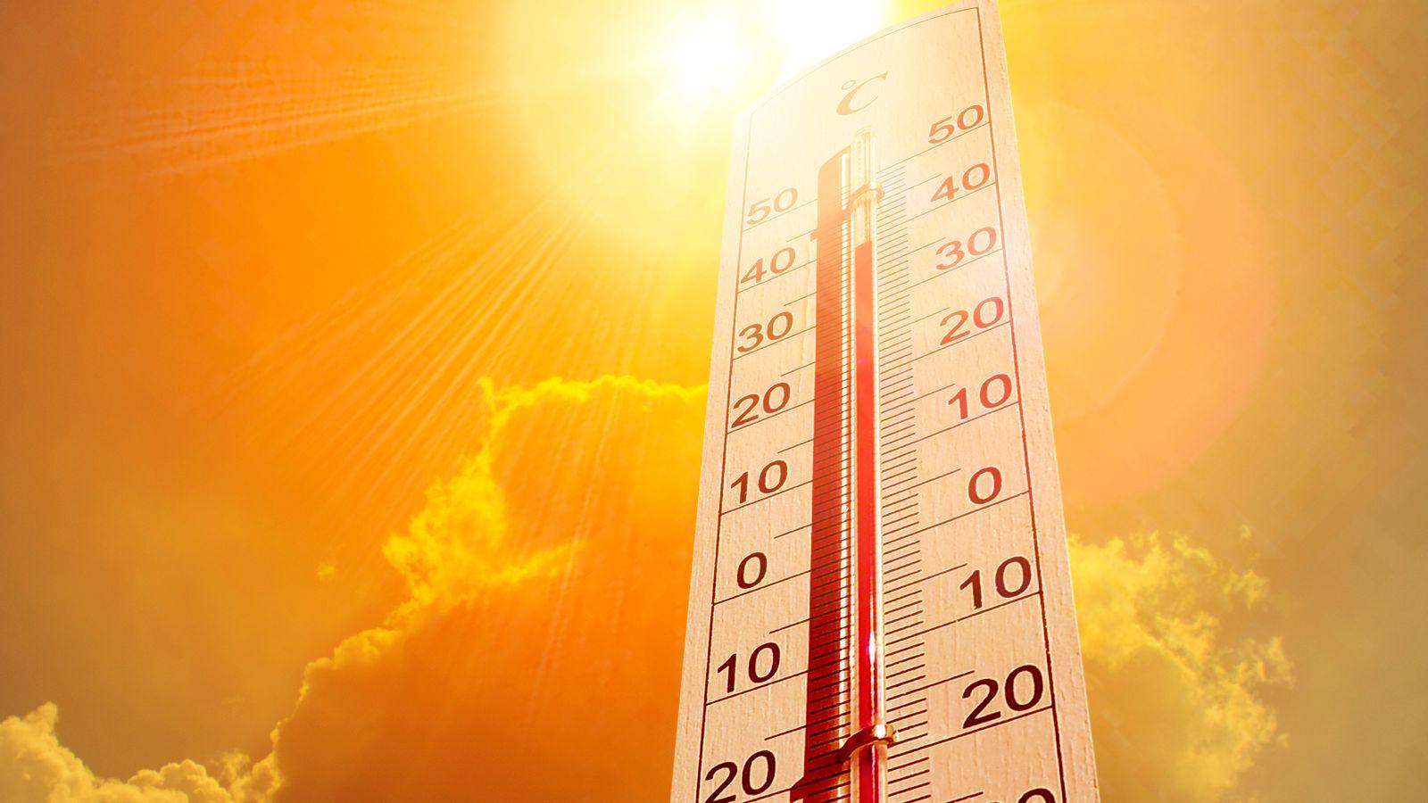 Termômetro marcando mais de 30 °C sob sol forte em céu alaranjado, simbolizando onda de calor.