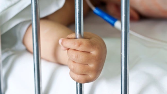 Mão de bebê hospitalizado segurando grade do leito em UTI, ilustrando caso de morte de bebê em Jundiaí.