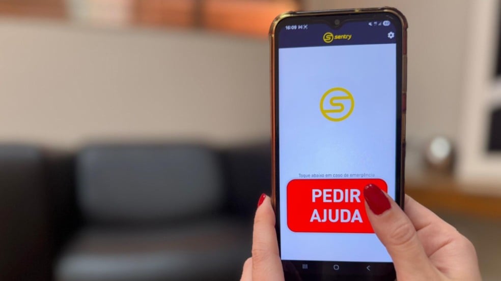 Tela do aplicativo SOS da Muralha Digital Sentry em um celular, mostrando o botão vermelho "PEDIR AJUDA" para acionamento em emergências.