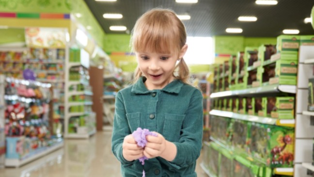 Menina feliz em loja de brinquedos durante a Campanha da ACE Jundiaí no Dia das Crianças