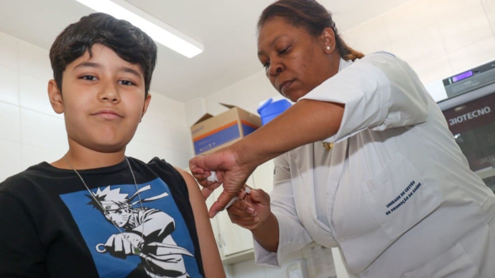 Profissional de saúde aplica vacina no braço de um menino durante a Campanha de Multivacinação em Jundiaí.