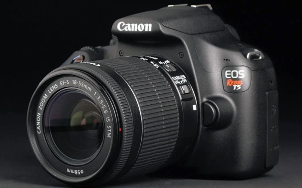 Câmera Canon EOS Rebel T5 DSLR com lente 18-55mm, destacando design compacto, corpo preto e botões de controle. Câmera Canon EOS Rebel T5 DSLR com lente 18-55mm, destacando design compacto, corpo preto e botões de controle.