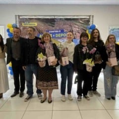 Autoridades e familiares posam para foto durante a inauguração do CEMEB Professora Adriana Tozetto em Itupeva, com flores e painel “Antes e Depois” ao fundo.