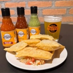 Prato com pastéis dourados acompanhados de molhos especiais e chope artesanal da Cervejaria Marcos Brunholi em Jundiaí.