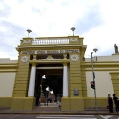 Entrada do Cemitério Nossa Senhora do Desterro em Jundiaí com fachada amarela e branca sob céu nublado.