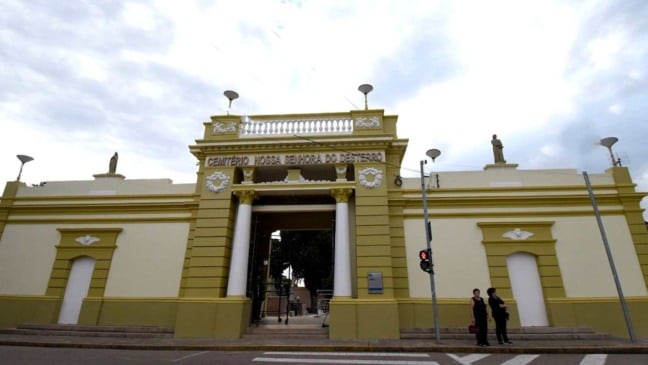 Entrada do Cemitério Nossa Senhora do Desterro em Jundiaí com fachada amarela e branca sob céu nublado. Entrada do Cemitério Nossa Senhora do Desterro em Jundiaí com fachada amarela e branca sob céu nublado.