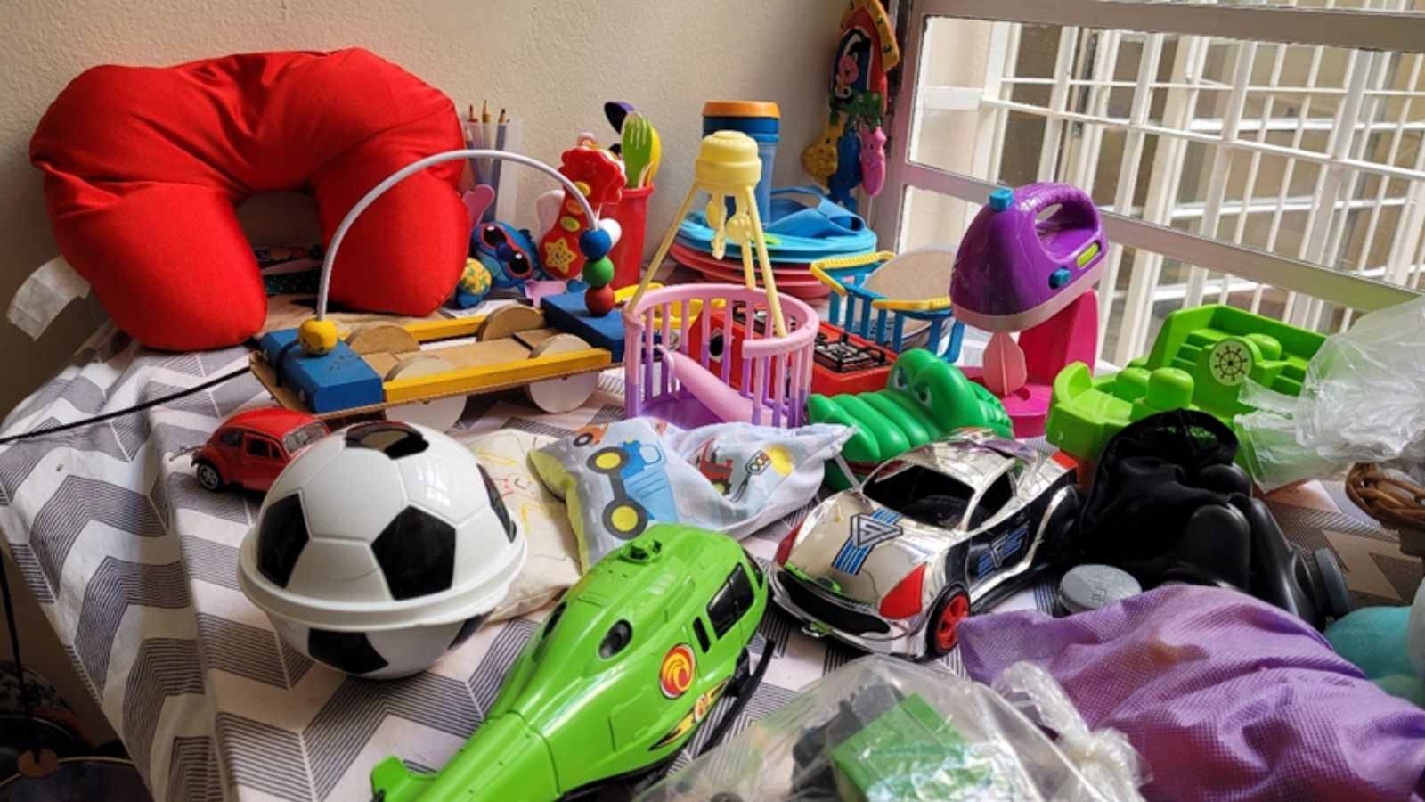 brinquedos e objetos infantis expostos em mesa no Bazar do Voluntariado do Hospital São Vicente, em Jundiaí.