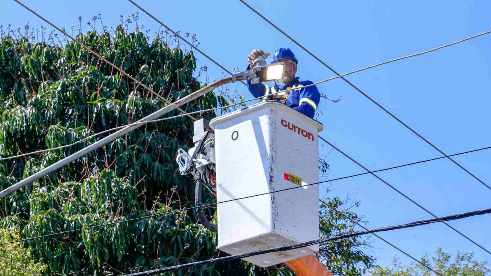 Funcionário em caminhão elevatório instala lâmpada de LED em poste de iluminação pública durante modernização da Avenida Capitão Francisco Copelli, em Jundiaí.