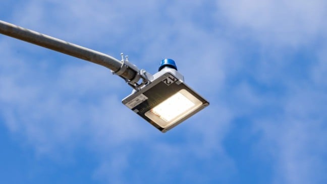 Luminária de LED em poste de rua com céu azul ao fundo, representando a nova iluminação pública no bairro Paiol Velho em Jundiaí.